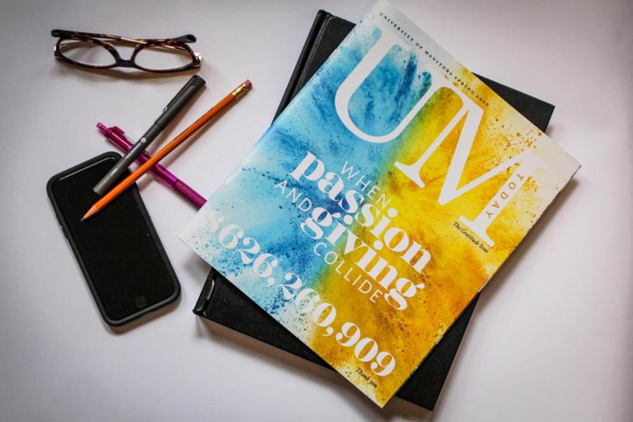 A table top with a cell phone, pens, reading glasses and a copy of the UM Today magazine. 