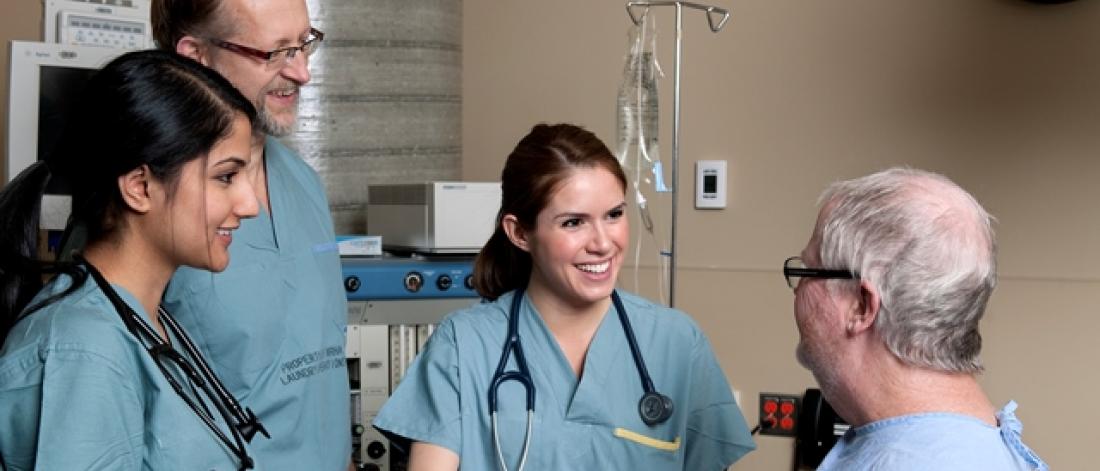 three doctors talking to a patient
