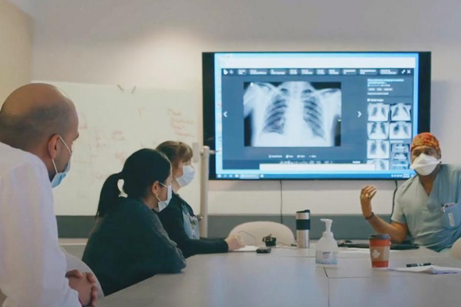A group of physicians sitting around a table, consulting on a patient case.