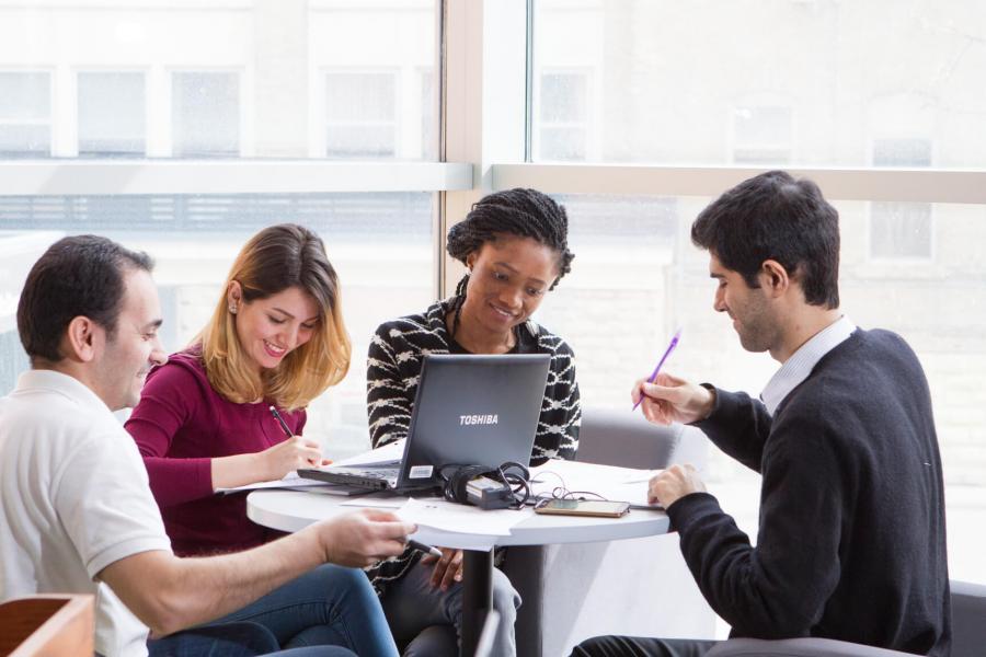 Four students study together at a table. 