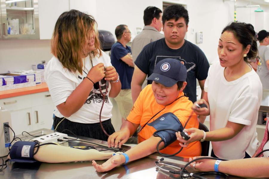 Students test blood pressure at open house event.