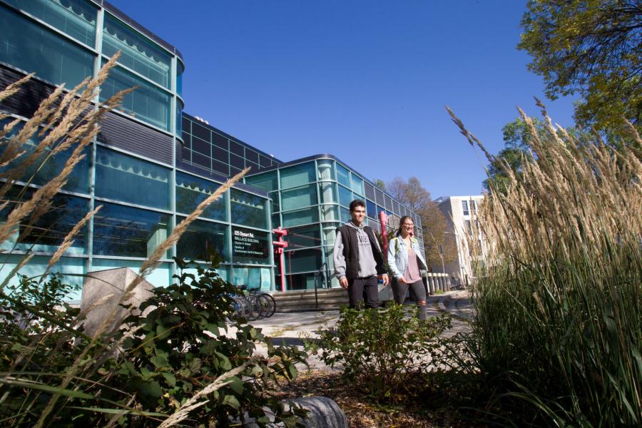 Two students walk as they exit the Earth Sciences and Environment building.